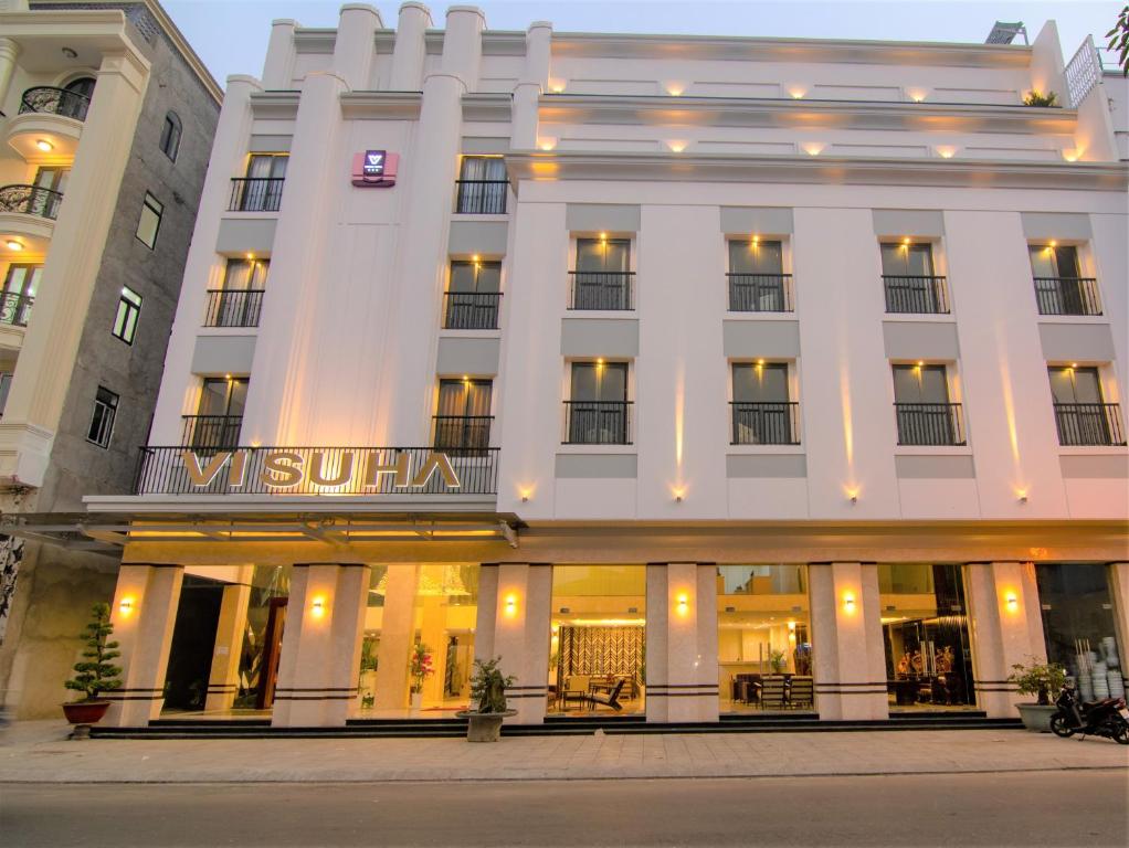 un edificio bianco con un cartello sopra di VISUHA HOTEL a Hà Tiên