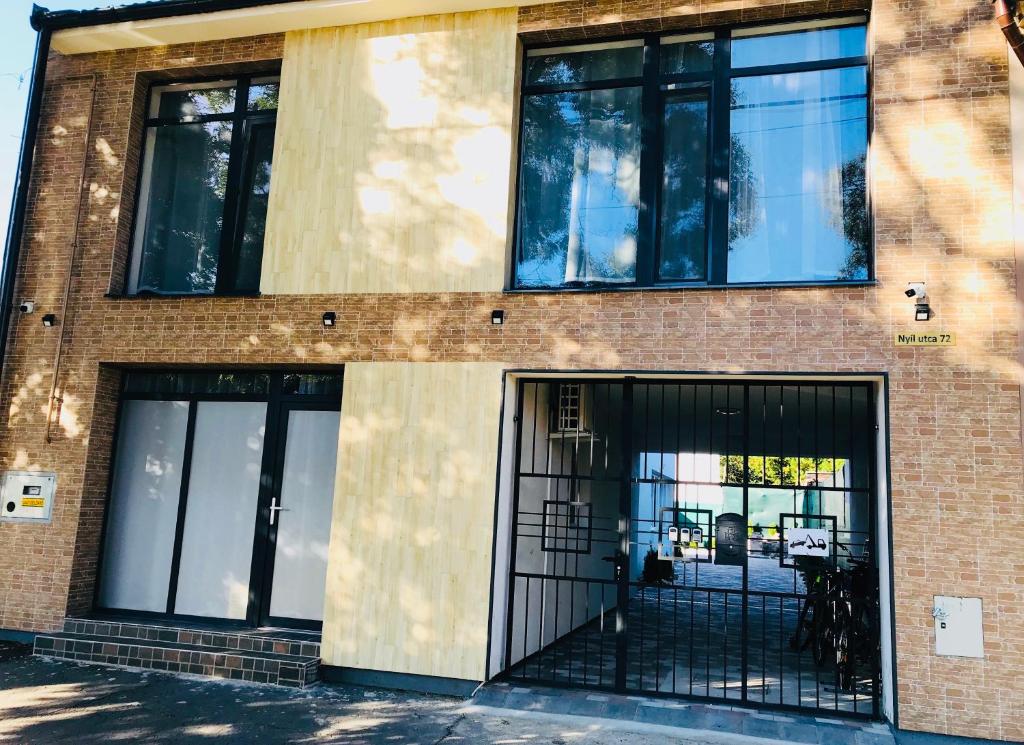 a brick building with black doors and windows at Mira apartman in Debrecen