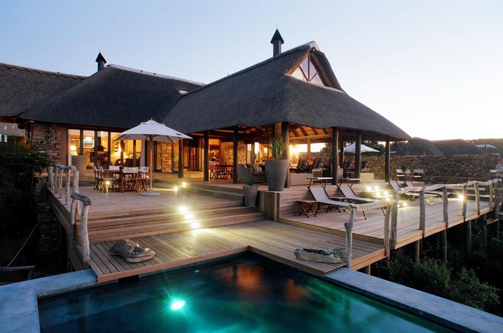 
a hotel room with a pool and a balcony at Pumba Private Game Reserve in Yarrow
