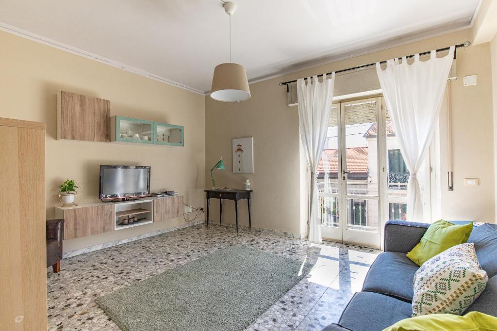 a living room with a blue couch and a tv at Appartamento Marco Polo in Viareggio