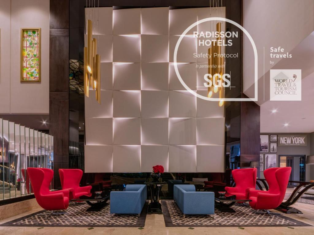 a lobby of a hotel with red and blue chairs at Radisson Blu Leogrand Hotel in Chişinău