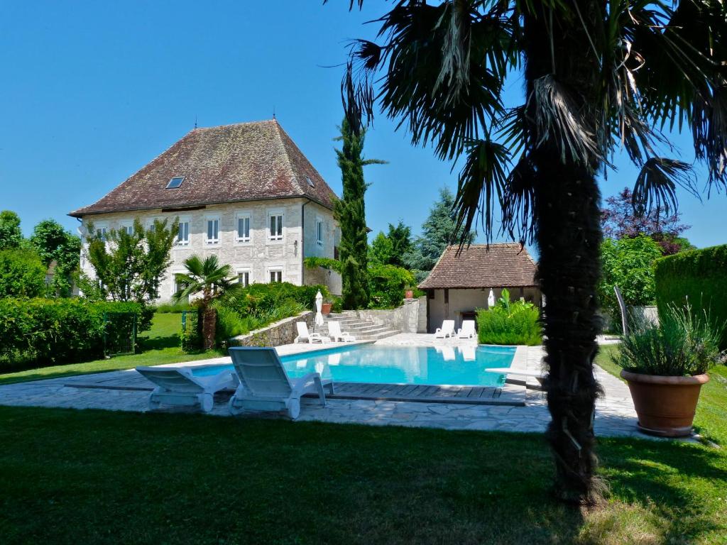 ein Haus mit einem Pool vor einem Hof in der Unterkunft Domaine du Manoir in Les Avenières