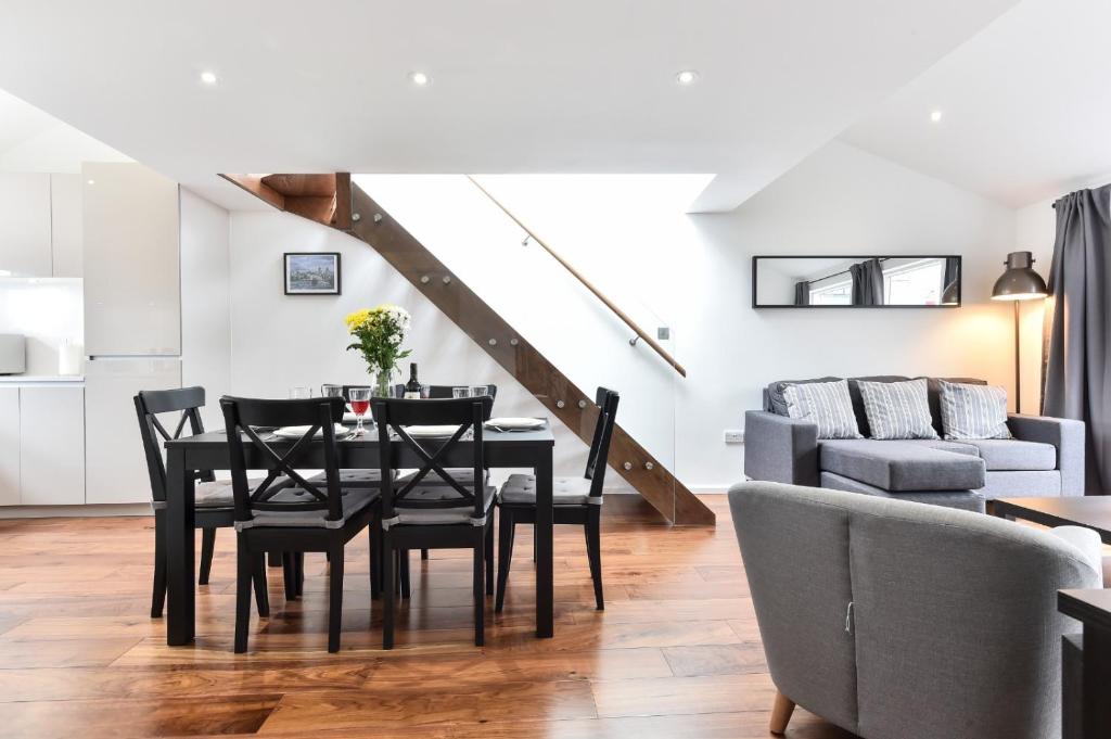a dining room with a table and chairs and a couch at Central Apartments in London