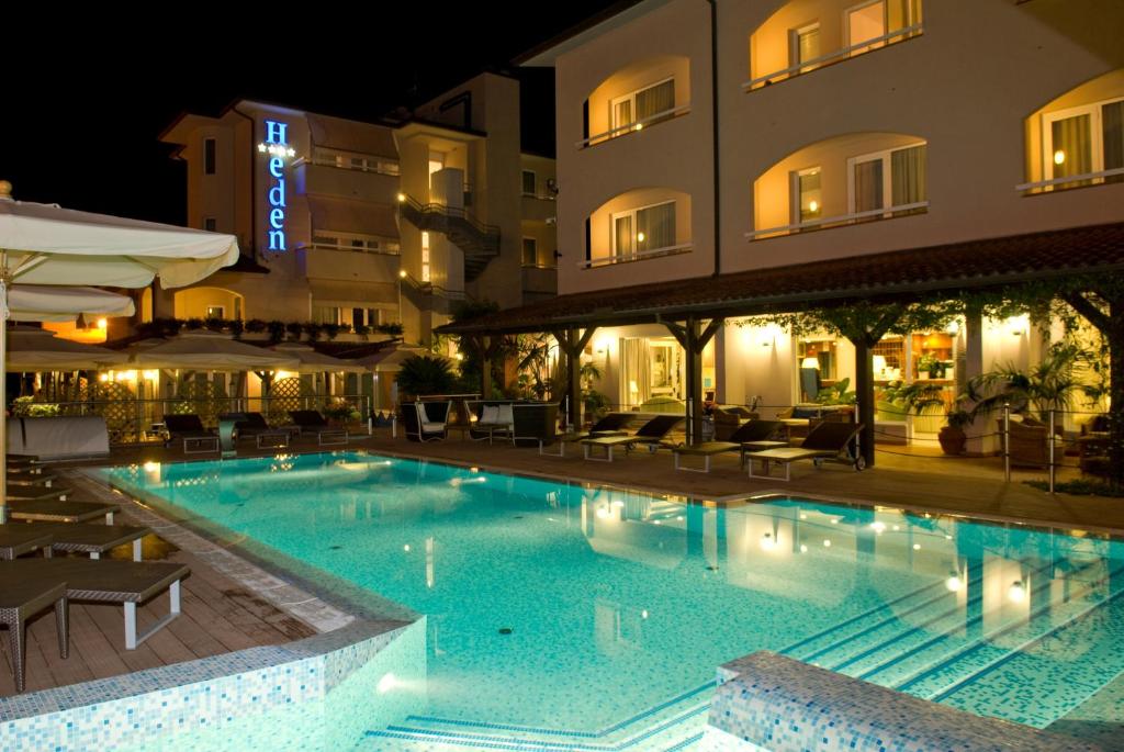 a swimming pool in front of a hotel at night at Hotel Eden in Cinquale