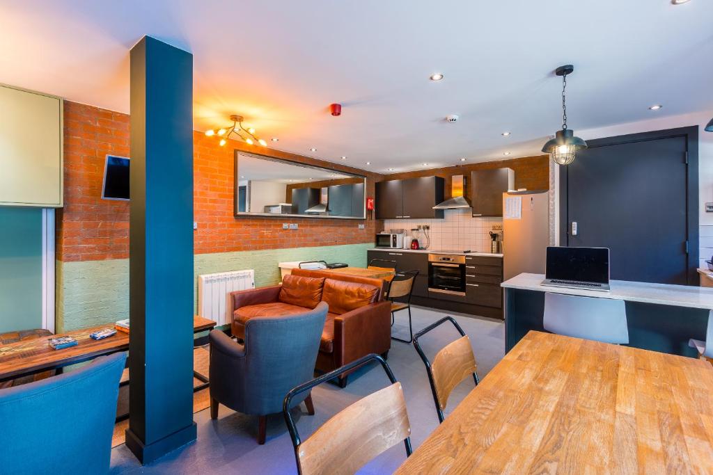 a kitchen with a table, chairs and a refrigerator at CoDE Co-Living – The LoFT - Edinburgh in Edinburgh