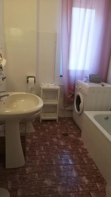 ein Badezimmer mit einem Waschbecken und einer Waschmaschine in der Unterkunft Casa Luna in Montesilvano