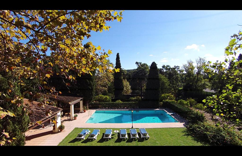 a swimming pool with lounge chairs and a yard at El Bikoro in Port de Pollensa