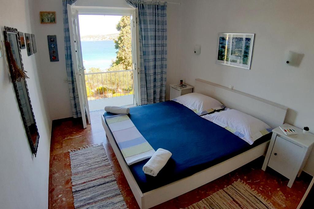 1 dormitorio con cama azul y vistas al océano en Apartment Merara, en Sevid