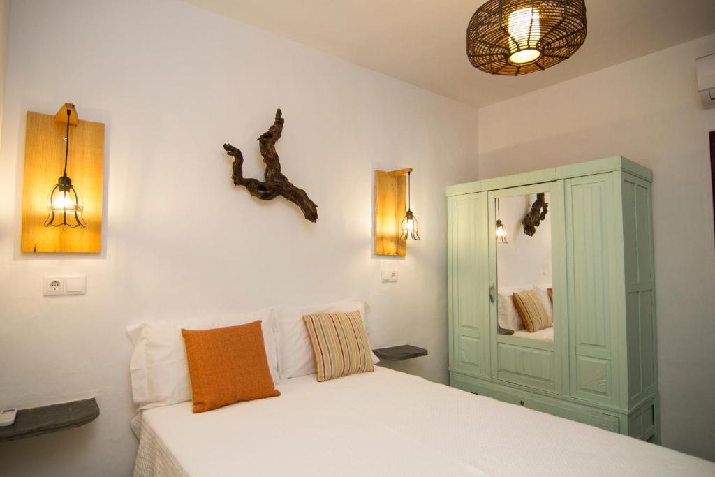 a bedroom with a white bed and a green cabinet at Casa da Orada in Outeiro