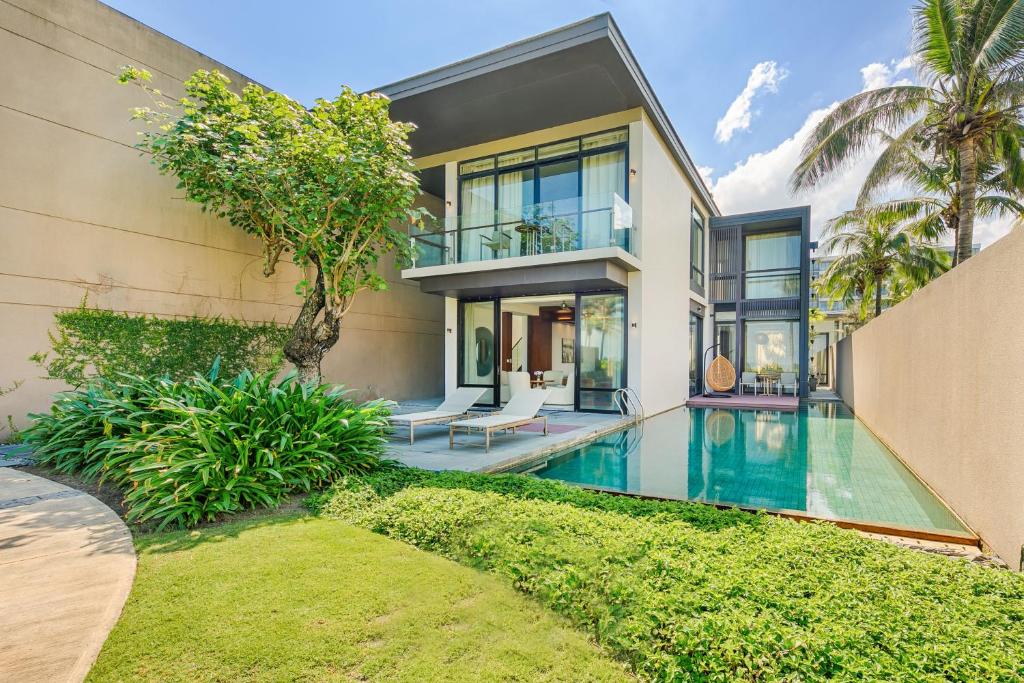 a house with a swimming pool in front of it at Abogo Resort Villas Beachview Da Nang in Danang