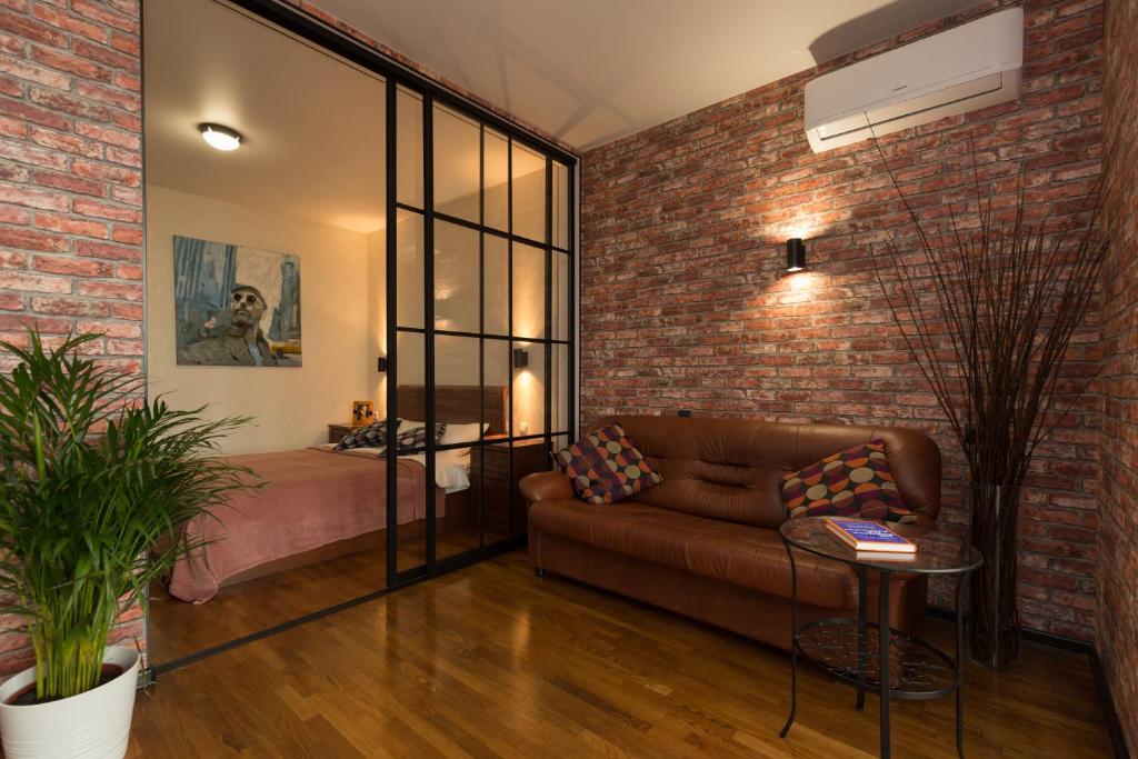 a living room with a couch and a brick wall at Апартаменты Азбука на Телецентре (Конгресс-Холл) in Ufa