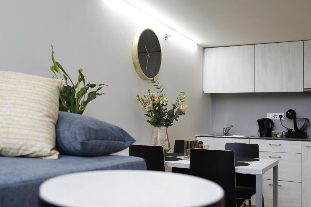 ein Wohnzimmer mit einem Sofa und einem Tisch sowie eine Küche in der Unterkunft Vita Sana Apartments&SPA - Family loft in Zlín