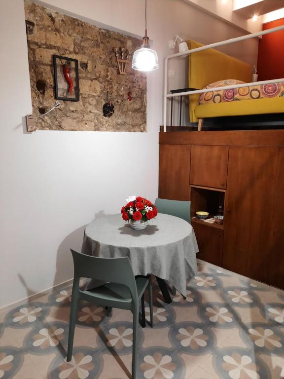 Zimmer mit einem Tisch, Stühlen und einem Bett in der Unterkunft IL BASSO ACCOMODATION in Neapel