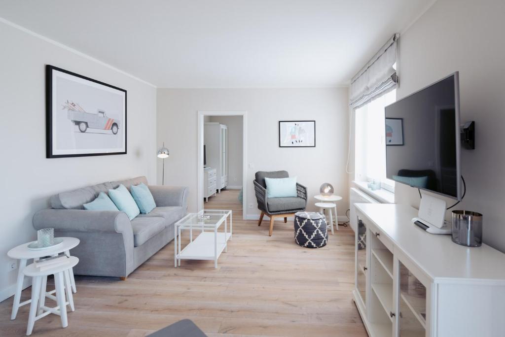 a living room with a couch and a tv at Anker Mal am Hafen in Husum