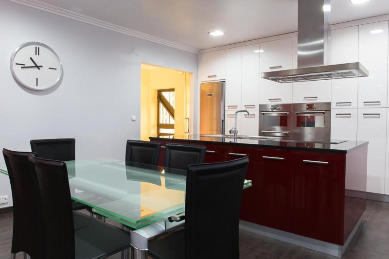 een keuken met een glazen tafel en een klok aan de muur bij AL-Formoso in Vilar Formoso