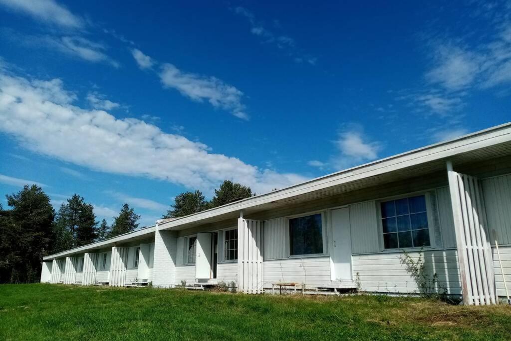 un edificio blanco en un campo con un cielo azul en Lokkankoti A, en Lokka
