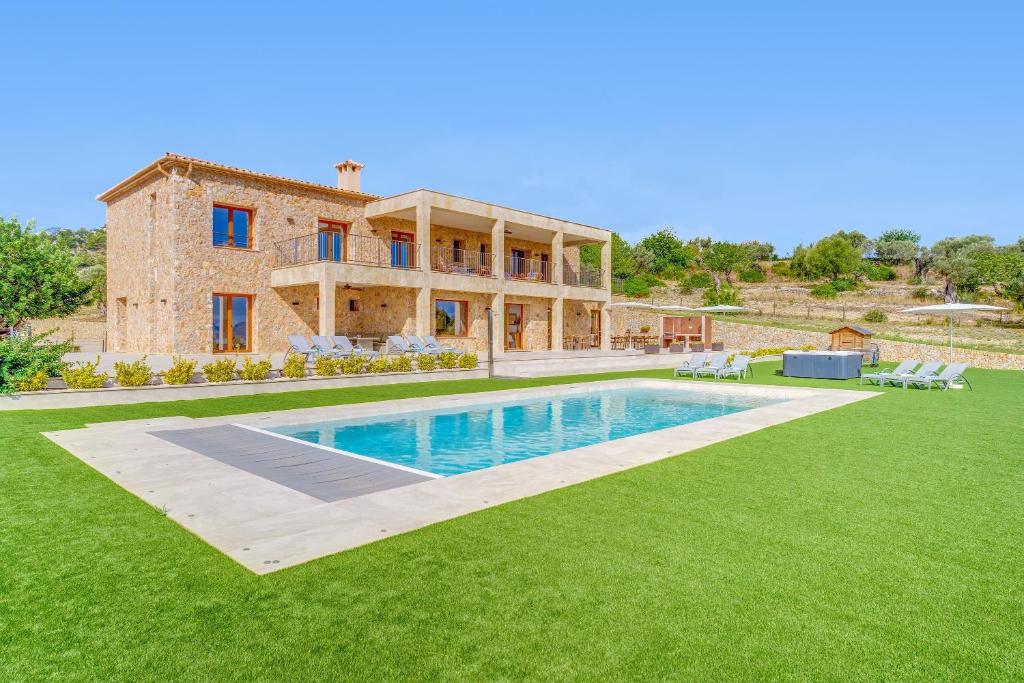 uma casa com um grande quintal com uma piscina em Ca'n Gatulux em Pollença
