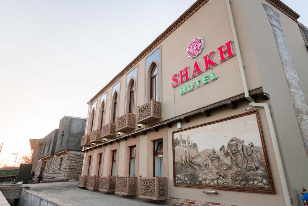 Un edificio con un cartel al costado. en Boutique hotel Shakh, en Bukhara