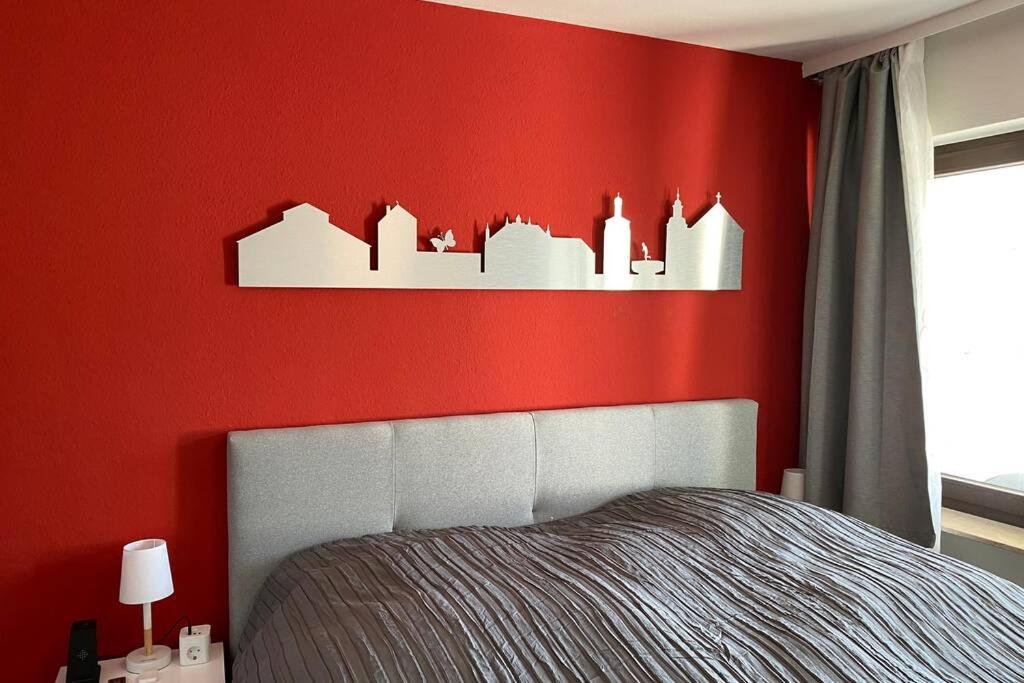 ベンドルフにあるAppartment mit Blick auf Schloss Saynの赤い壁のベッドルーム(ベッド付)
