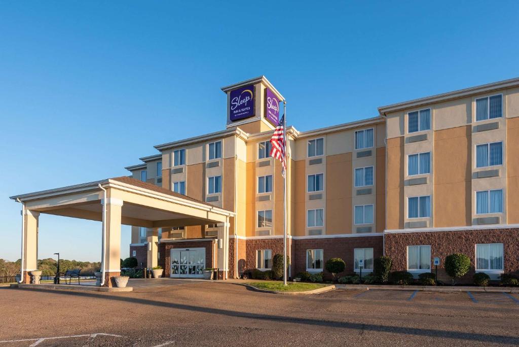 een hotel met een Amerikaanse vlag ervoor bij Sleep Inn & Suites Ruston Near University in Ruston