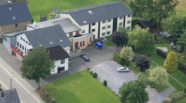 une vue aérienne sur une grande maison avec un parking dans l'établissement Hotel zum Buchenberg, à Saint-Vith