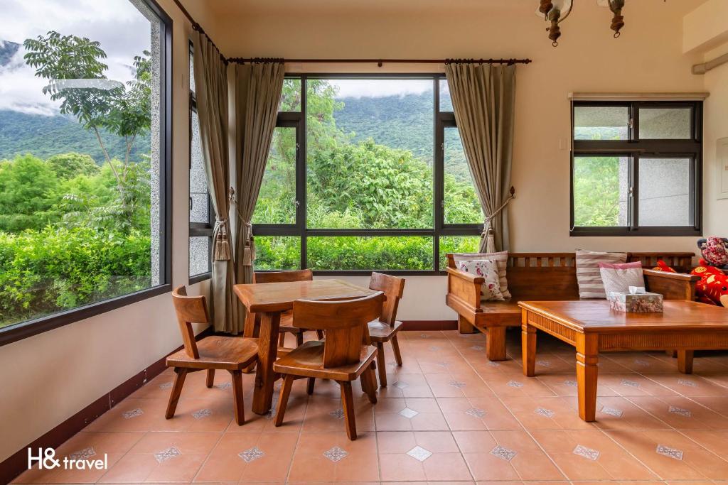 a living room with a table and chairs and large windows at Qian B&amp;B (Taroko) in Jiamin