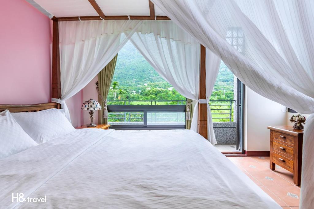a bedroom with a large bed and a large window at Qian B&amp;B (Taroko) in Jiamin