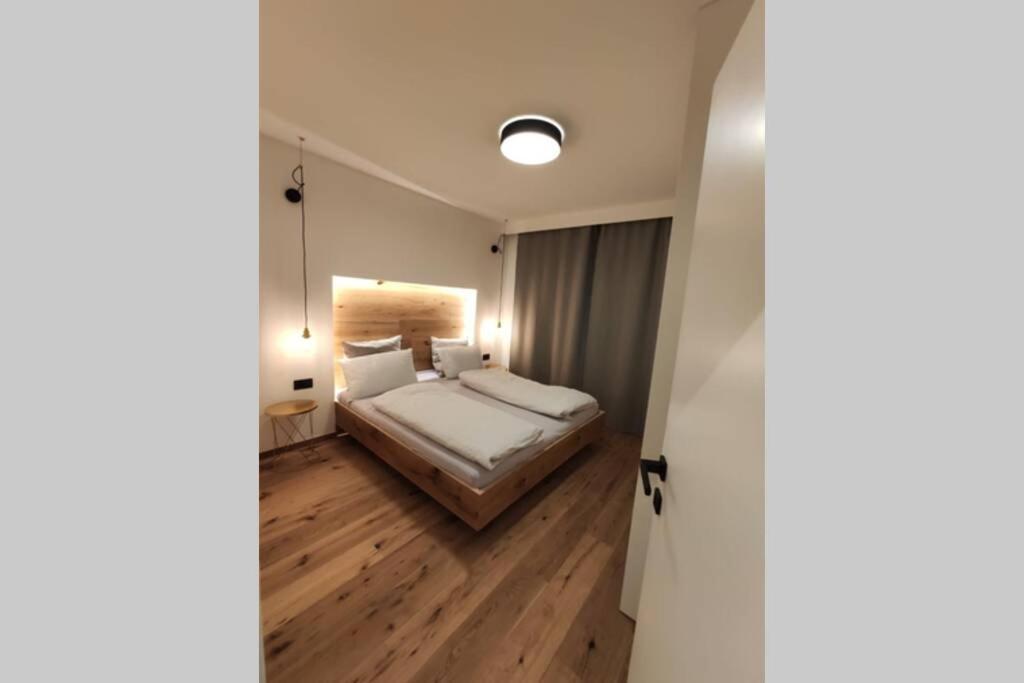 ein Schlafzimmer mit einem großen Bett und Holzböden in der Unterkunft Appartement Toni in Sand in Taufers