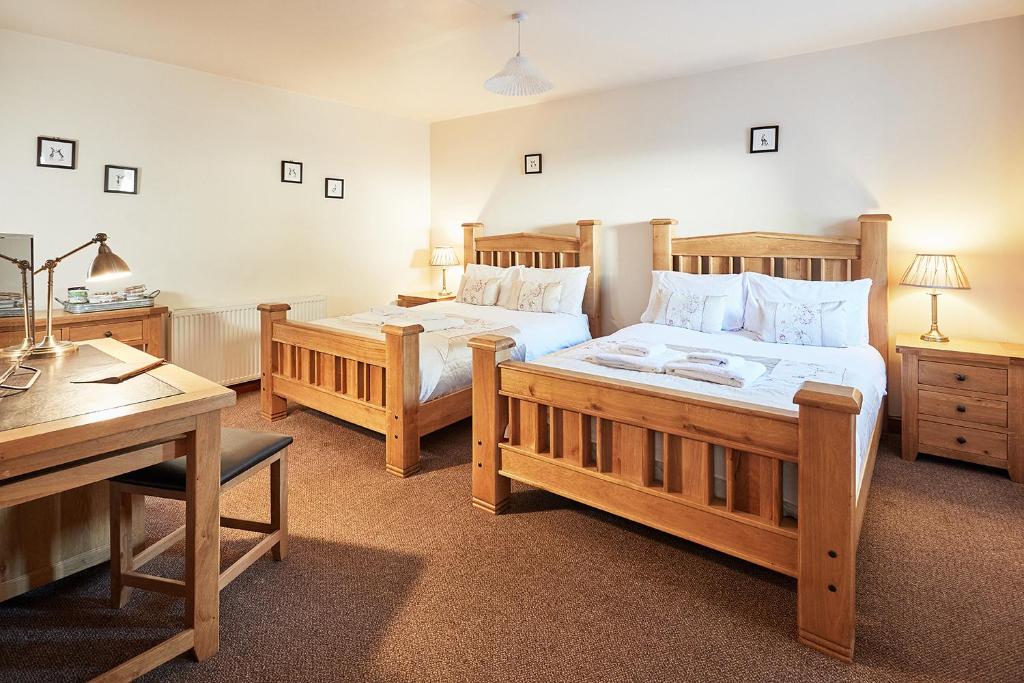 a bedroom with two beds and a desk at The Bateman Arms at Shobdon in Shobdon