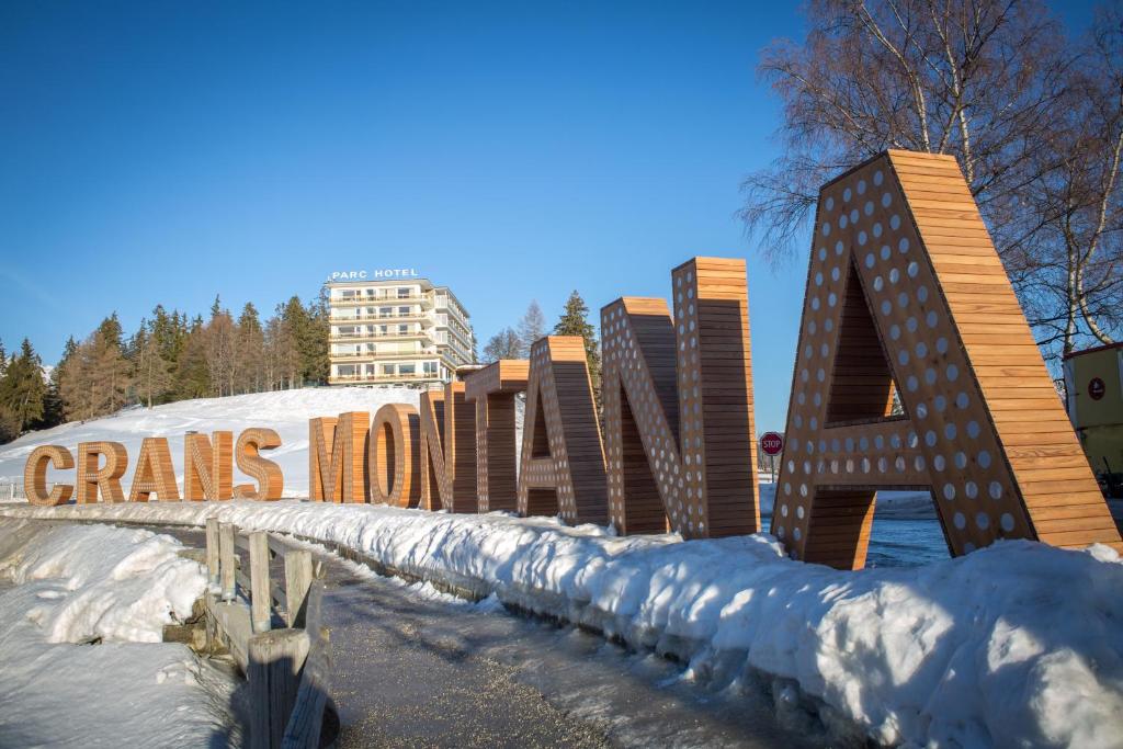 ein Gebäude mit einem Schild im Schnee in der Unterkunft Grand Hôtel du Parc in Crans-Montana