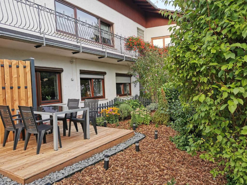 a wooden deck with a table and chairs in a yard at Haus Froehlich in Michelstadt