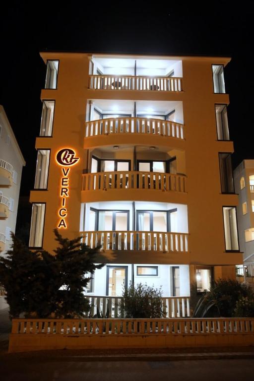 a tall yellow building with a sign on it at Villa Verica in Baška Voda