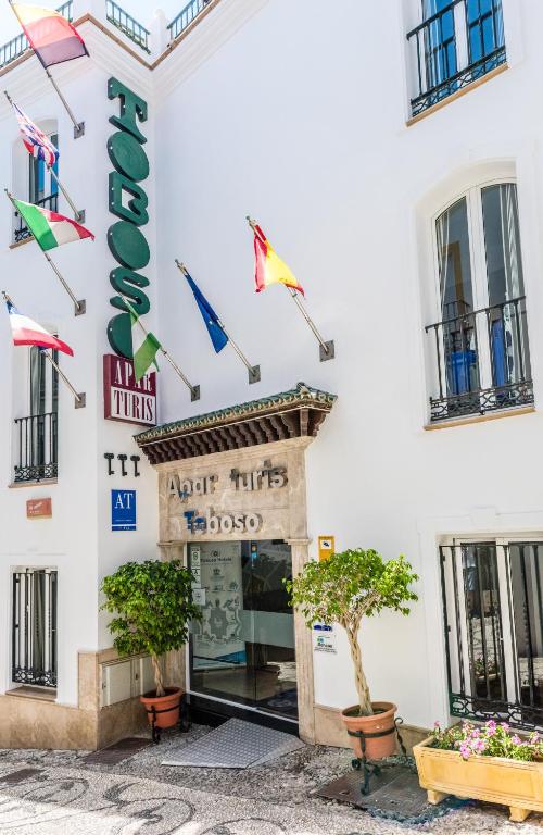 a white building with a sign that reads art hits melbourne at Toboso Apar - Turis in Nerja