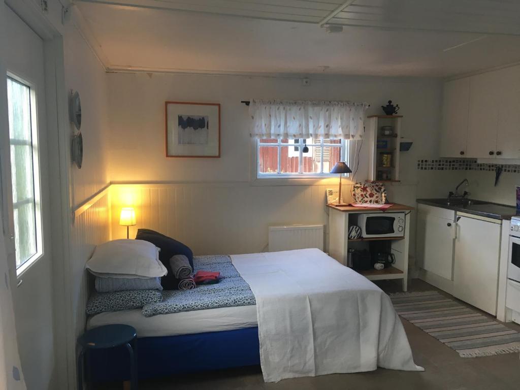 a small bedroom with a bed and a kitchen at Lillstugan Elofstorp in Kristinehamn
