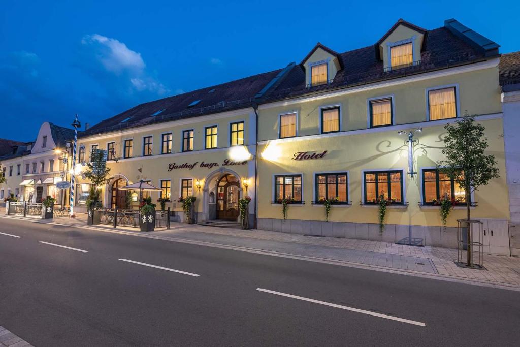 a large white building on the side of a street at Hotel Bayrischer Löwe in Osterhofen