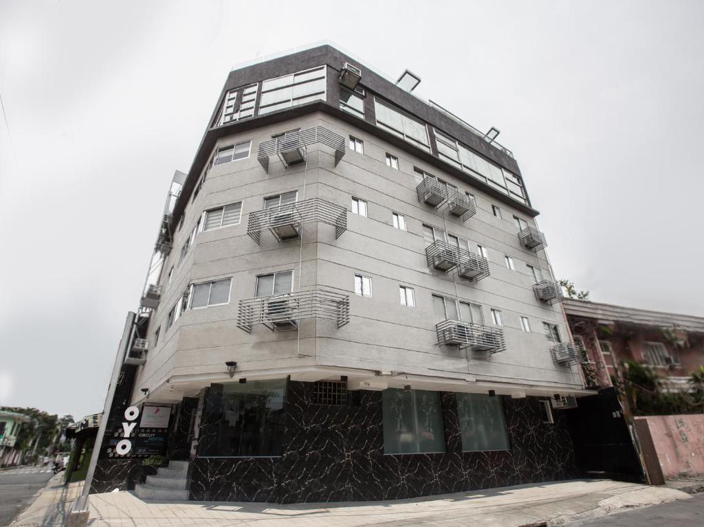 un grand bâtiment blanc avec balcon dans une rue dans l'établissement OYO 675 Circuit Hostel, à Manille