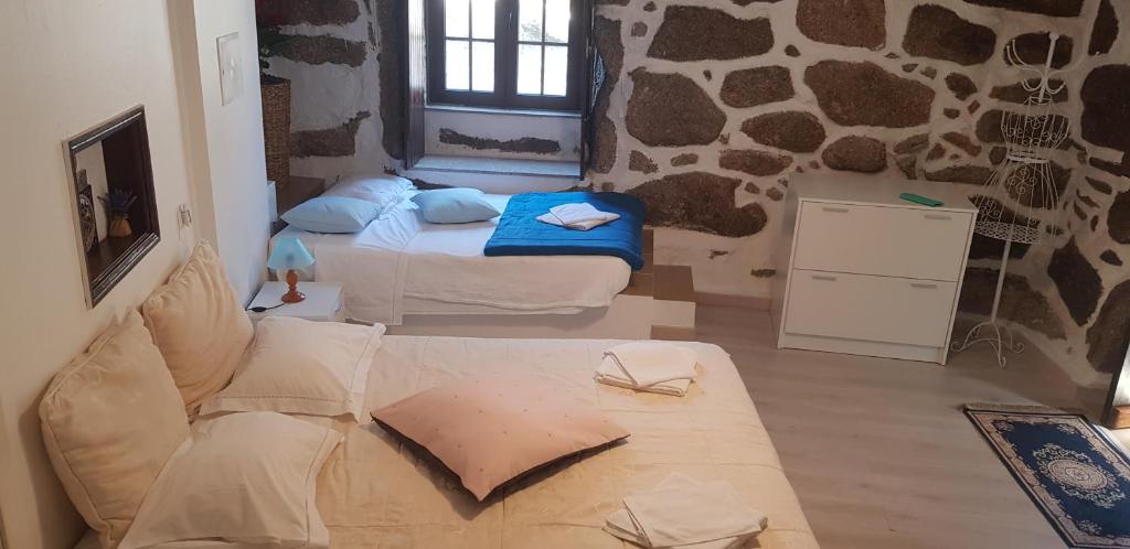 uma sala de estar com duas camas e um sofá em Casa Bento Teixeira em Belmonte