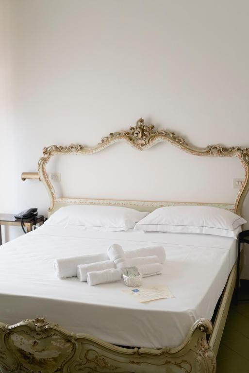 a white bed with white towels on it at Mami Sabaudia Hotel in Sabaudia