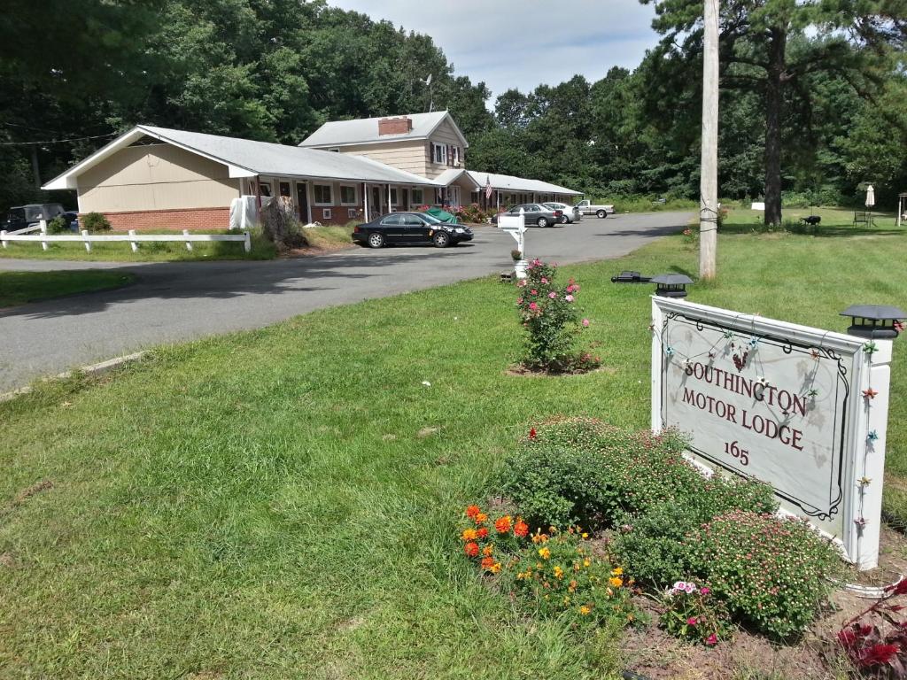 a sign in the grass in front of a building at Southington Motor Lodge in Southington