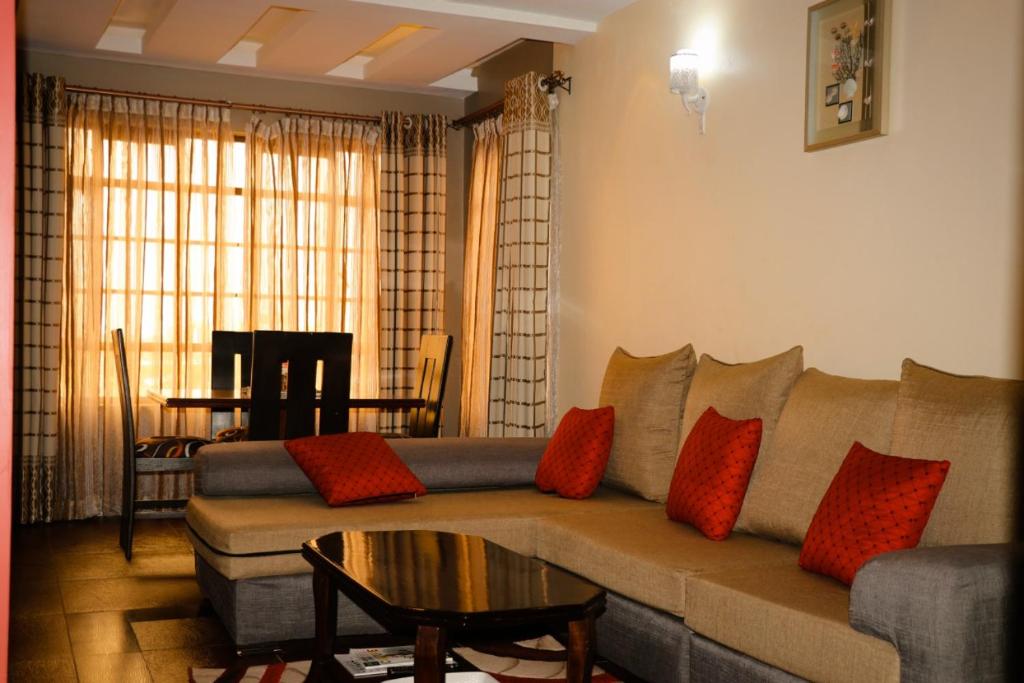 ein Wohnzimmer mit einem Sofa und einem Tisch in der Unterkunft Vienna Apartments in Nairobi