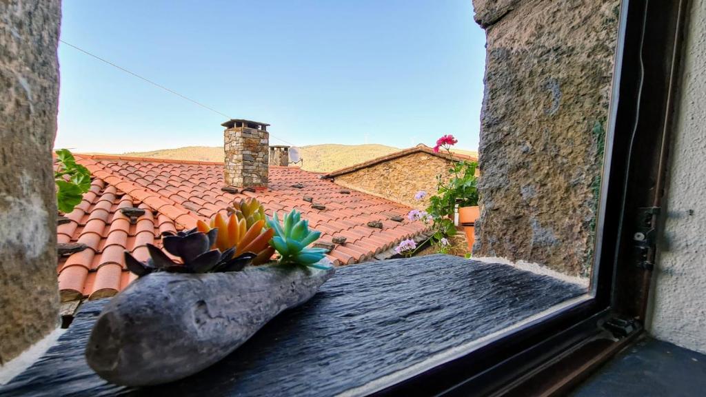 een raam met uitzicht op een dak bij Casa Catraia Gondramaz no Pulmão da Serra da Lousã in Gondramaz