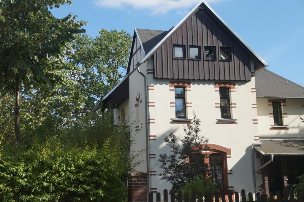 une maison blanche avec un toit noir dans l'établissement Villa 1895, à Leipzig