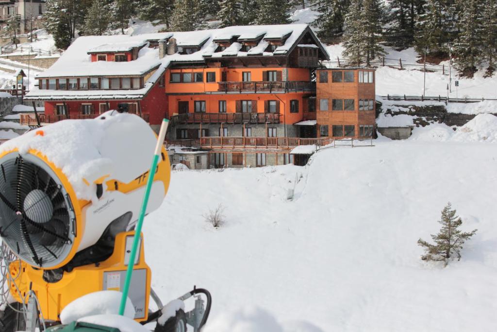 um edifício na neve com um snowmobile em Hotel Al Foiron em Claviere