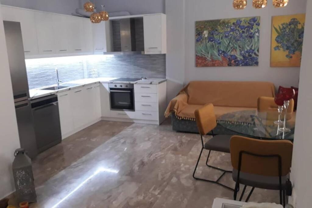 a kitchen and living room with a couch and a table at IRIS by Amanakis Family in Hersonissos