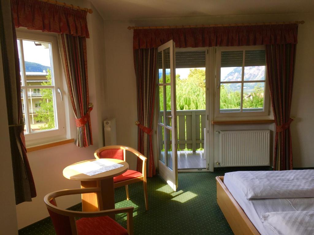 um quarto de hotel com uma cama, uma mesa e cadeiras em Hotel Turmwirt em Ora