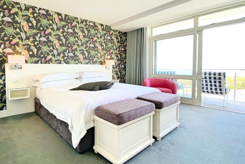 a bedroom with a large bed and a large window at One Marine Drive Boutique Hotel in Hermanus
