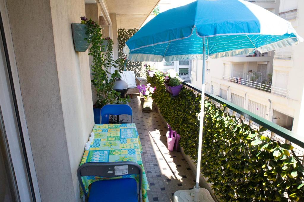 un ombrello blu e alcuni bagagli sul balcone di Chill Out Apartment, 2 mins from beach a Nizza