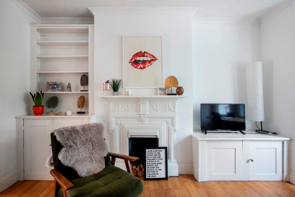 a living room with a fireplace and a chair at Pass the Keys - Beautiful stylish flat in South West London in London