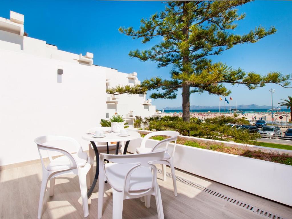 a table and chairs on a balcony with a view of the ocean at Apartment Oiza Classic, at Alcudia Beach in Port d'Alcudia