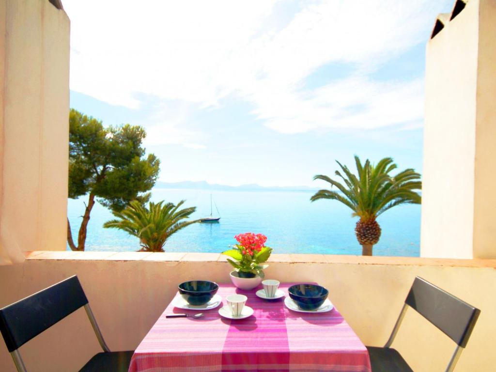 een tafel met een tafelkleed op een tafel met uitzicht op de oceaan bij Apartment Vida Sana with Sea Views and Garden in Port d'Alcudia